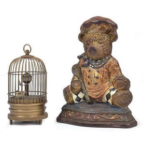 A painted cast iron novelty door stop and a small singing bird…