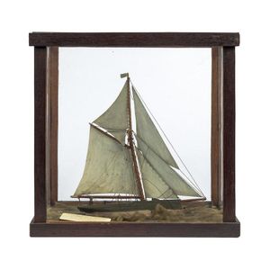 A model yacht diorama in display case with attached note…