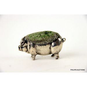 A novelty sterling silver pin cushion in the form of a pig,…