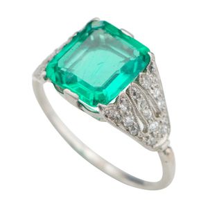 An Art Deco platinum emerald and diamond ring, Centering an…