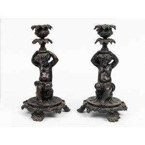 A pair of bronze figural candlesticks, 19th century, with…