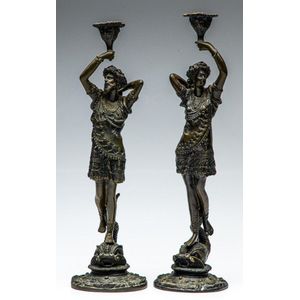 A pair of figural bronze candlesticks with dauphin bases,…