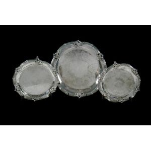 Three silver plated circular trays. With scroll rim and raised…