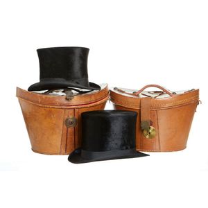 Two black silk top hats in their original leather hat boxes,&hellip;