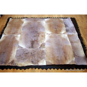 A kangaroo pelt rug, a patchwork rectangular floor rug, backed…