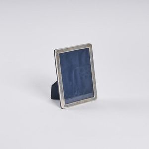 A silver photo frame, with a blue velvet backing. With…