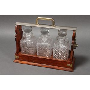 Edwardian three bottle tantalus, in golden oak, accented with…