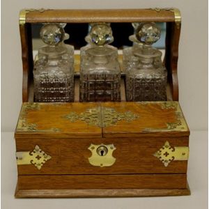 Edwardian English oak three decanter tantalus with brass…