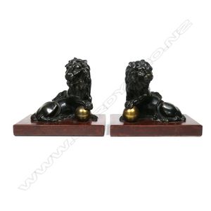 A pair of bronze Imperial lion bookends, modelled in mirrored…