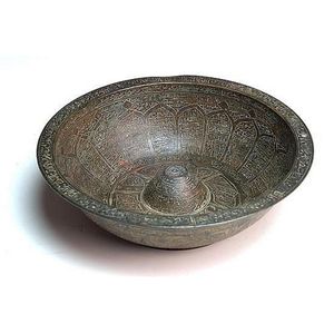 An Islamic ceremonial vessel, with Arabic text incised over…