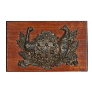 A cast iron 'Advance Australia' coat of arms, on a blackwood…