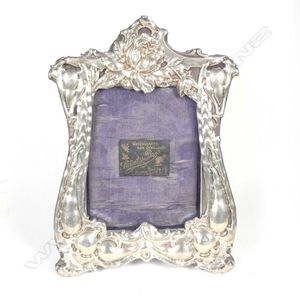 An Edwardian silver photo frame, embossed with flowers and…