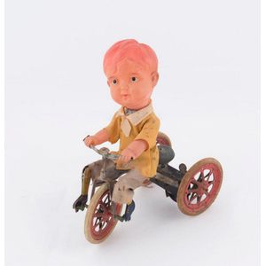 Vintage tinplate boy on tricycle, celluloid head and arms,…