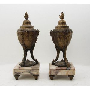 A pair of French gilt metal covered urns supported on marble…