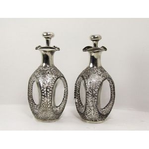 A pair of silver mounted glass brandy decanters. 26 cm high.