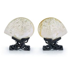 A pair of mother of pearl shells, each carved and pierced with…