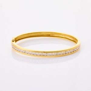 18ct yellow gold, channel set diamond hinged bangle, consisting&hellip;