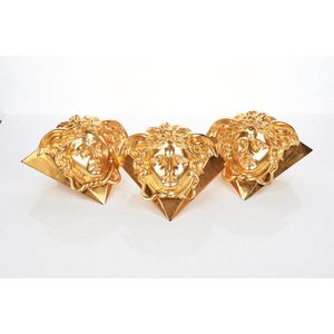Versace, three Medusa wall lamps, electrified, cast brass in…