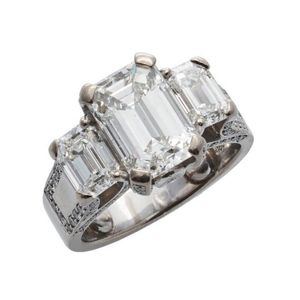 An important three stone diamond ring, featuring one emerald…