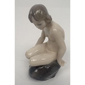 A Royal Copenhagen, Denmark porcelain figure of girl on a stone,&hellip;