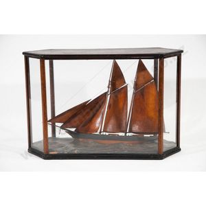 Diorama display of a 19th century sailing ketch in a wedge…