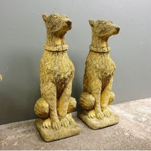 A pair of church stone classical seated hound dogs, their backs…