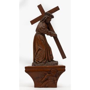 An antique carved oak statue of Christ bearing the cross on…