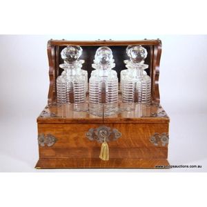 A Victorian oak tantalus, 19th century. The mirror backed…