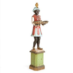 A wooden blackamoor figure on stand, with arms outstretched…
