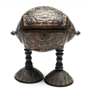 A 19th century carved coconut lift top jewellery box on legs,…