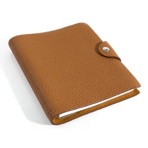 A leather notebook by Hermes, styled in tan leather with silver…