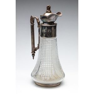 A silverplated and cut crystal claret jug with bear finial,…