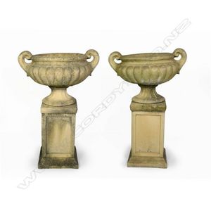 A pair of Church Stone classical garden urns on stands,…