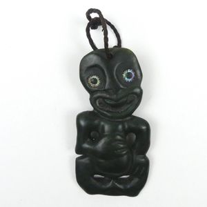 A pounamu hei tiki, in Taranaki style, with upright head, ring…
