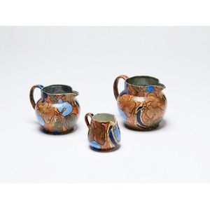 Frederick Rhead, three Bursley Ware Amstel jugs, painted…