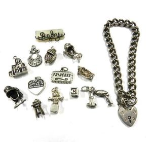 A collection of sterling silver baby charms and a curb link…