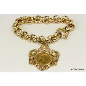 A gold bracelet with serpent set coin pendant. The bracelet…