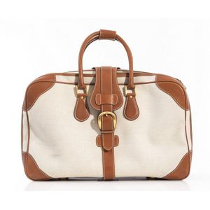 A suitcase by Gucci, styled in cream canvas and tan pigskin…