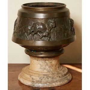 A cast bronze jardiniere, on marble stand, depicting a…