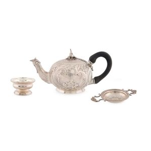 An Elizabeth II sterling silver tea strainer and stand by…