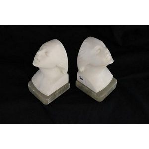 A pair of Art Deco carved white marble bookends, of the young…
