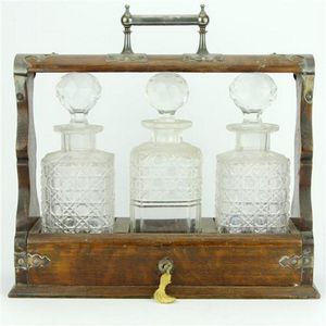 Victorian oak three bottle tantalus with a silver plated handle…