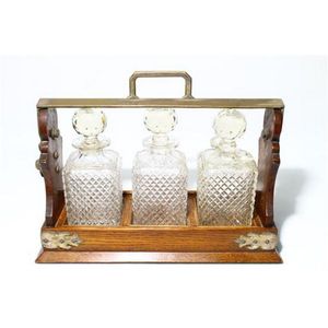 An oak cased three bottle tantalus, three matching decanters,…