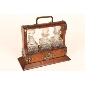 Edwardian oak Petit tantalus set with three liquer bottles and…