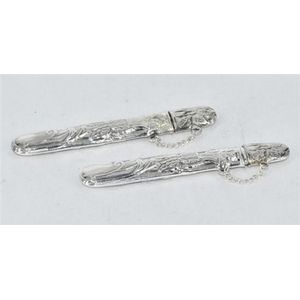 Pair of sterling silver needle cases, with light floral design.…
