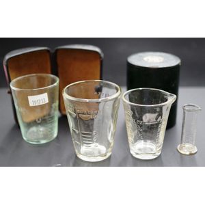 Two various cased medicine glasses each with a calibrated…