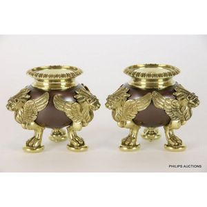 A pair of heavy gauge bronze winged lion candlesticks, cauldron…