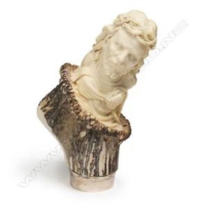 A vintage antler walking stick handle, carved with the figure…