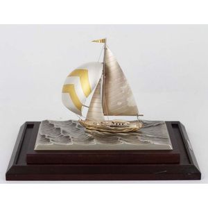A silver model yacht on stand, silver yacht, gilded spinnaker,…