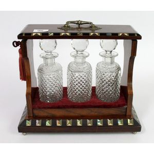 A Victorian rose wood tantalus, three bottles, with paua shell…